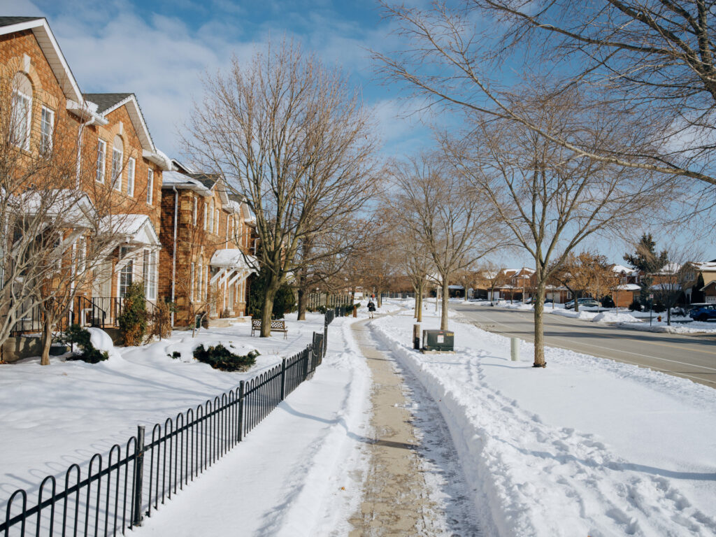 Sunlight-filled residential street in Oakville, Ontario, representing a peaceful and warm home transition when downsizing after a divorce.
